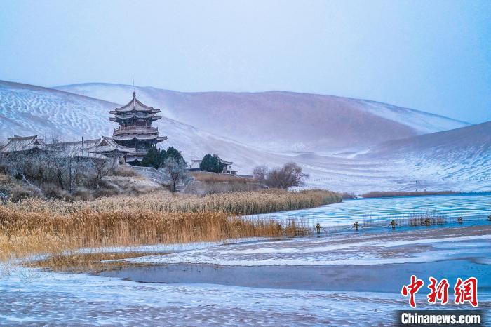 2021年11月28日，雪落鳴沙山月牙泉景區(qū)?！⊥醣筱y 攝