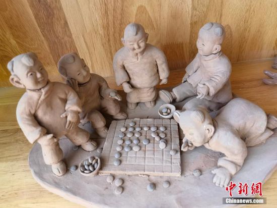 圖為泥塑作品展現(xiàn)下棋場(chǎng)景。 劉玉桃 攝