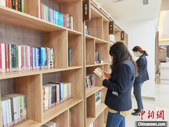 圖為在甘肅公航旅建設集團有限公司的職工書屋，職工挑選書籍?！⌒煅?攝